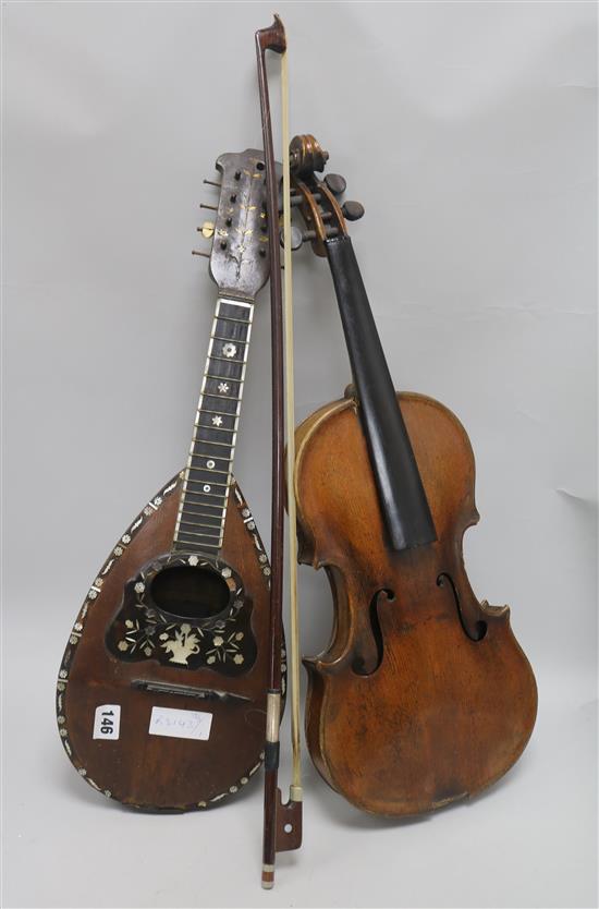 A violin, bow and a mother of pearl inlaid mandolin